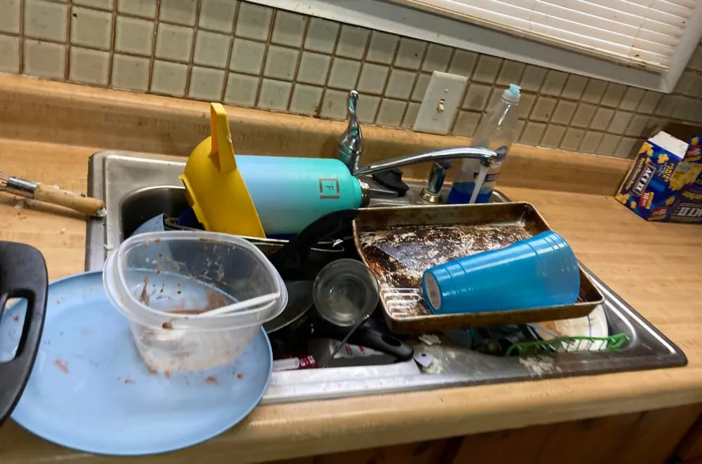 Kitchen sink filled with dirty dishes and bakeware